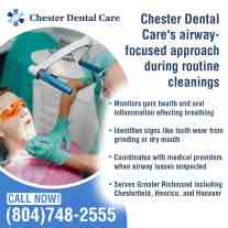 A dental hygienist wearing safety glasses and blue gloves is examining a male patient’s mouth during a routine cleaning.