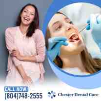 A happy woman smiling next to a dental patient receiving an exam with a mirror at Chester Dental Care.